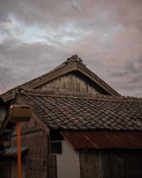 Minka roof detail, with small statues, possible of Ebisu, on the roof crown.