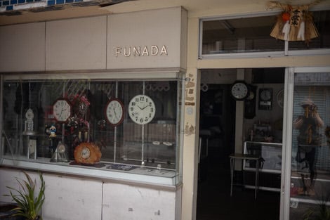 An old clock store with old cloks on display in the window.
