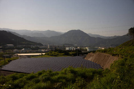 A solar panel array sat betwen a few mountains.