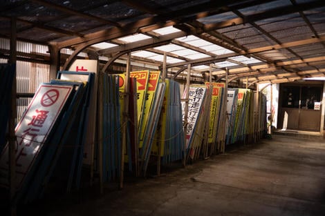 Signs piled against one another in a shed.
