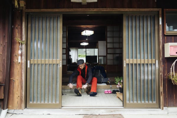 Craig Mod putting on his shoes at Minshuku Yamamoto