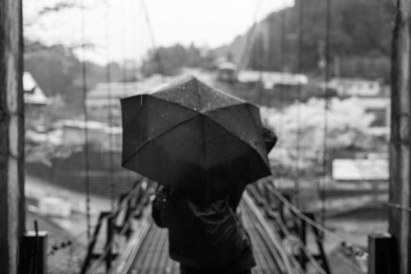 Matt Mullenweg holding an umbrella before a bridge at the foot of Miura Guchi
